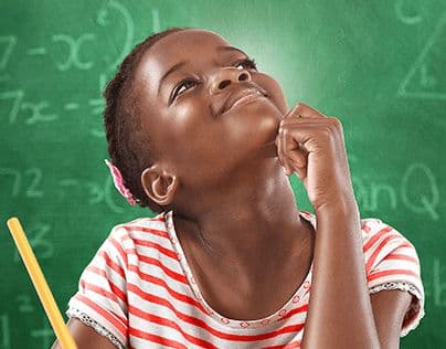 Jeune fille noire pensive souriant devant un tableau vert couvert d'équations mathématiques complexes.